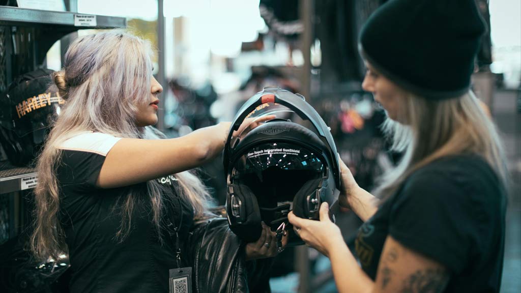 Women looking at motorcycle helmets
