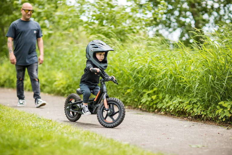 Child riding IRONe on a path.